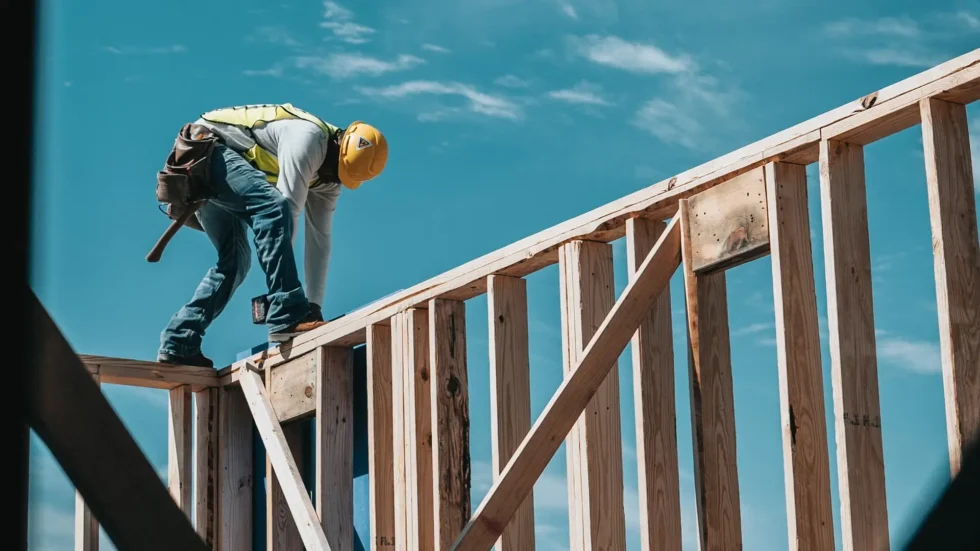 A worker on the frame of a home under construction.